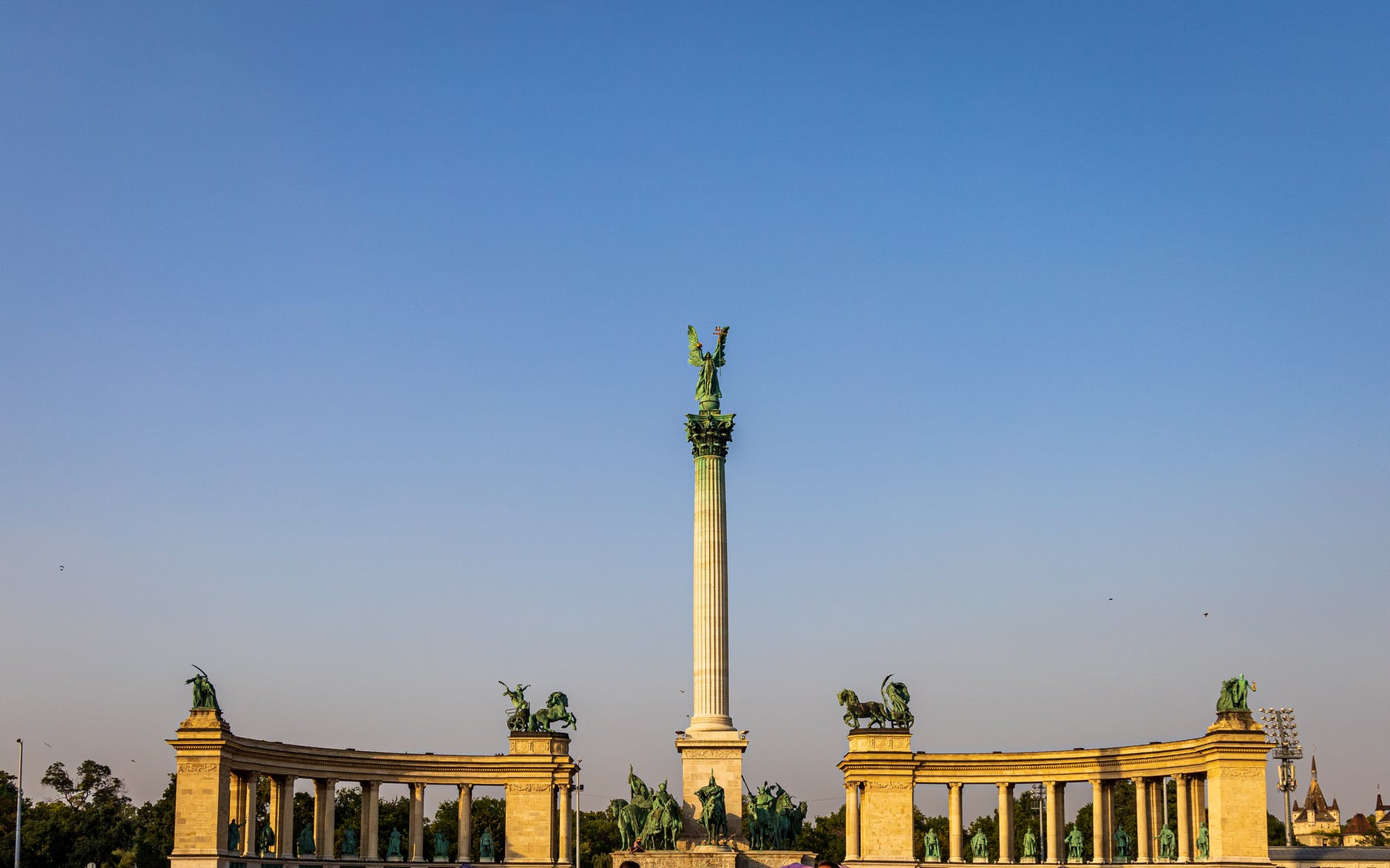old column with statue in middle of square